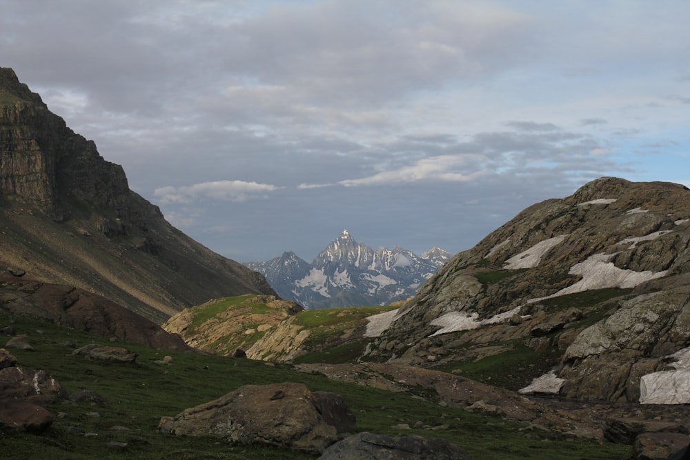 montagnes vertes et brunes sous des nuages blancs pendant la journée