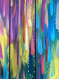Abstract artwork featuring vibrant, flowing brushstrokes in a variety of colors. The paint is applied in vertical streaks with thick, textured layers, interspersed with dotted white patterns that add a dynamic contrast.