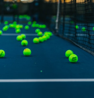 green tennis balls on tennis court