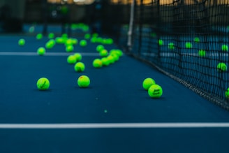 green tennis balls on tennis court