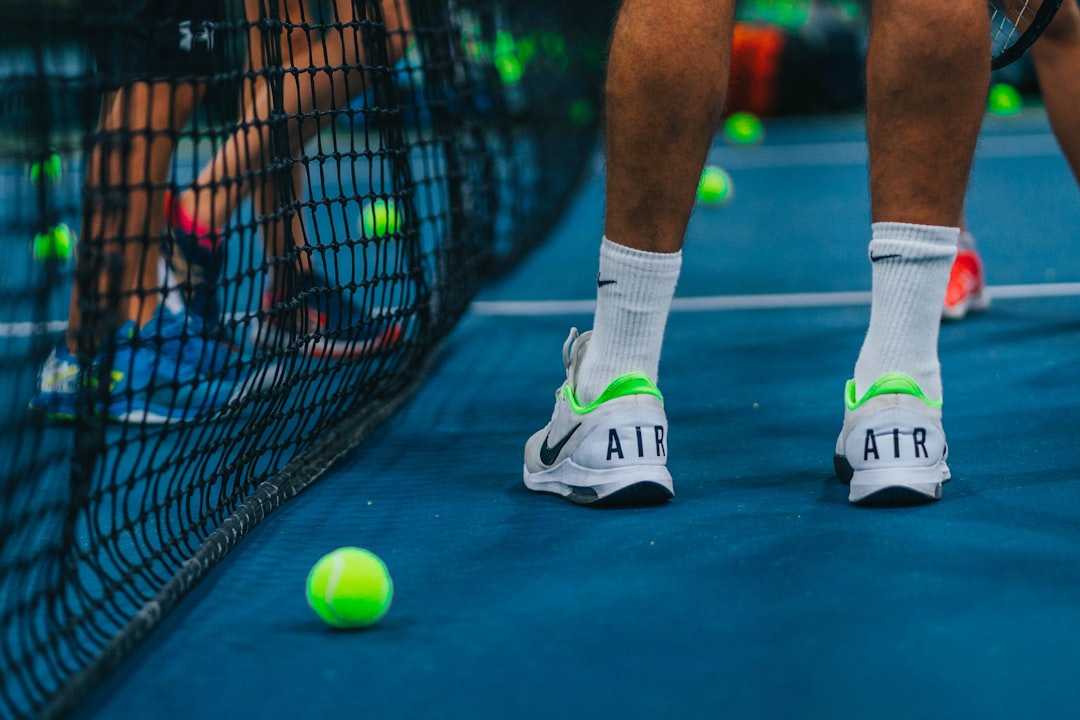 person in white and green nike athletic shoes