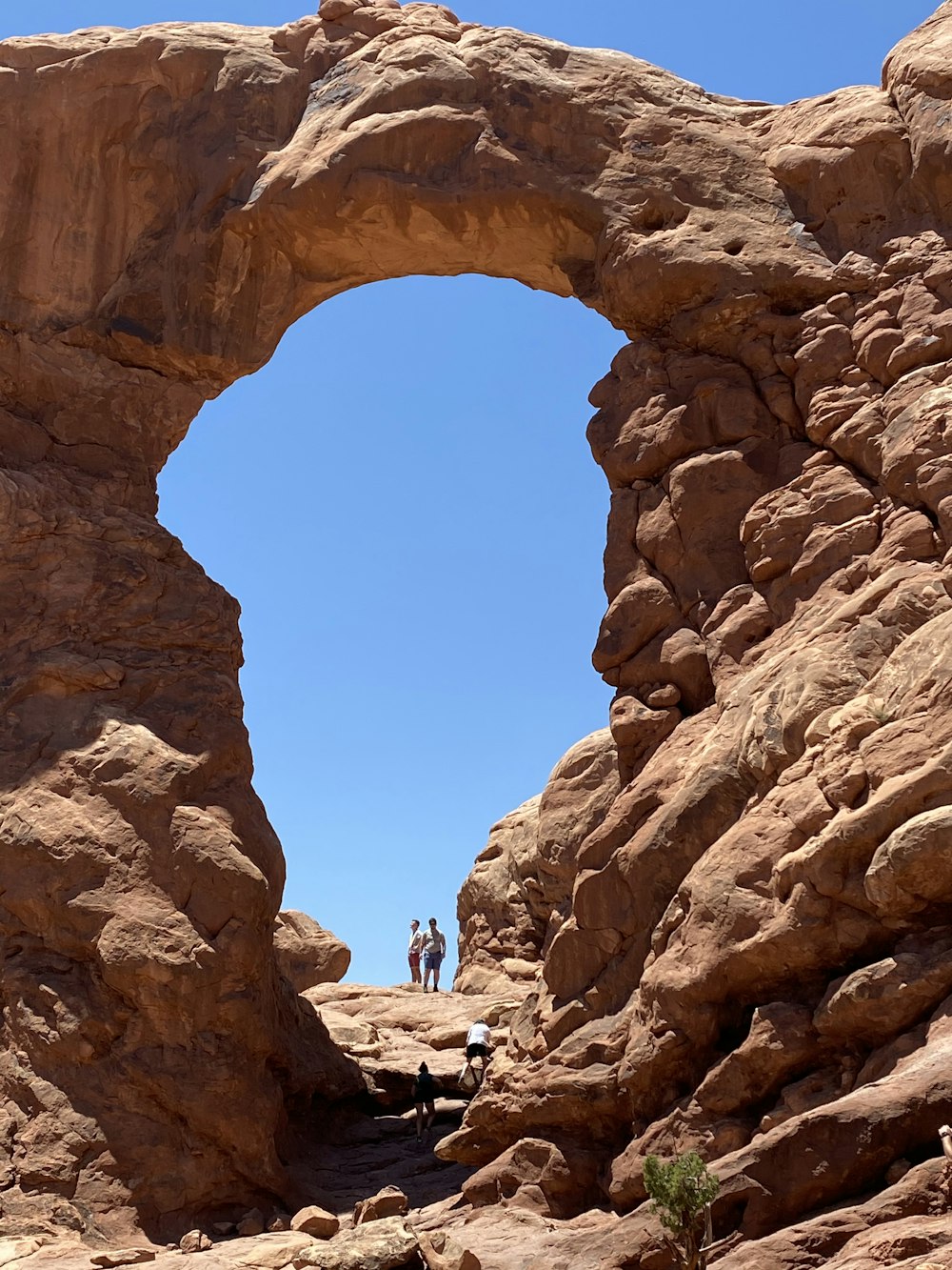 people walking on brown rock formation during daytime