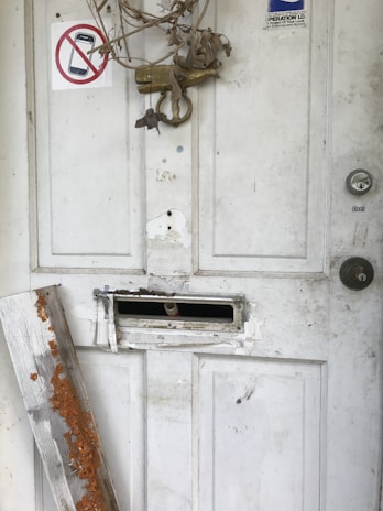 A guest looking distressed while inspecting a damaged hotel room door.