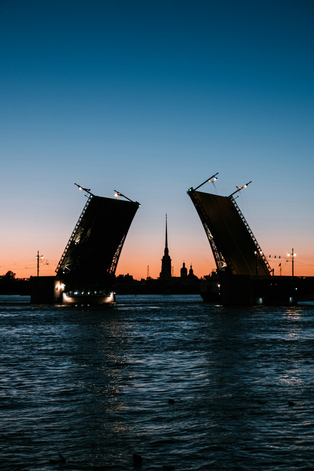 silhouette of building near body of water during sunset