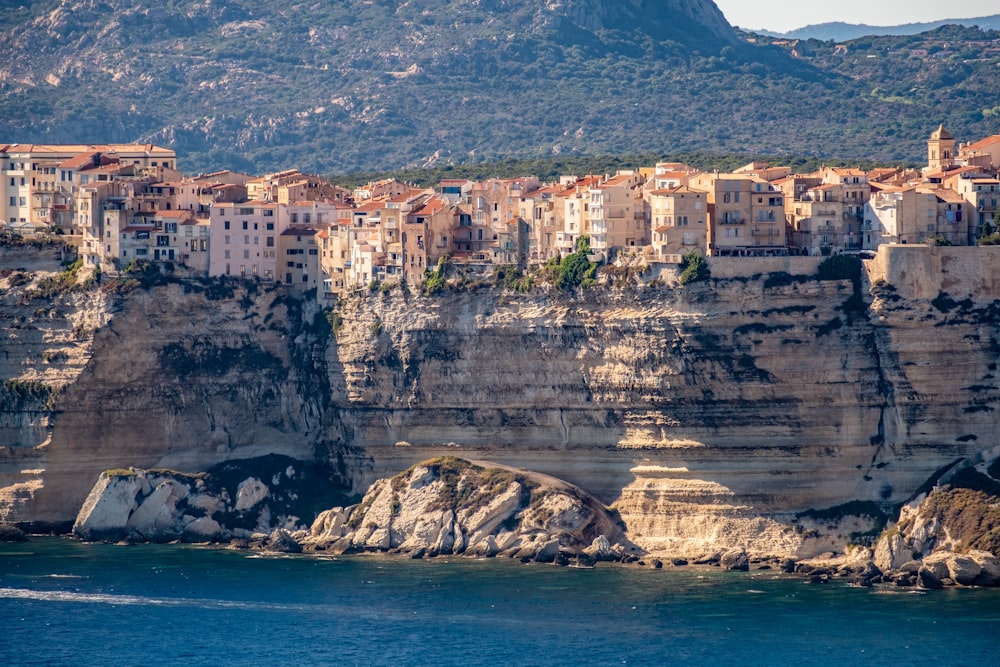 Bâtiment en béton brun sur une falaise au bord de la mer pendant la journée