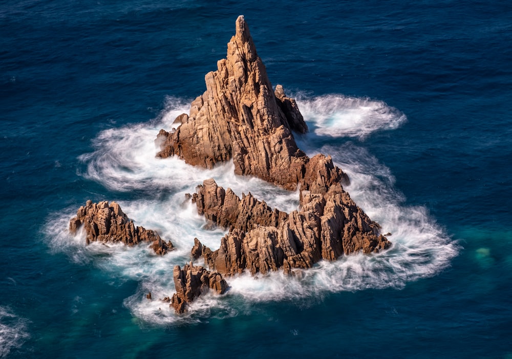 昼間の海上の茶色の岩層