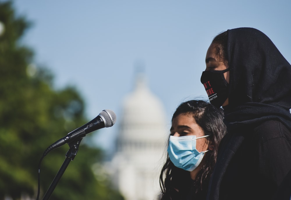 man in black jacket wearing white mask