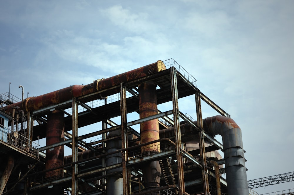 brown metal tower under white clouds during daytime