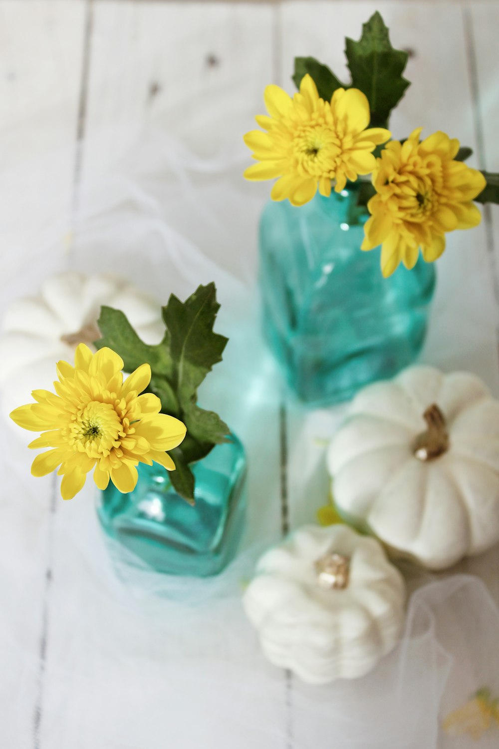 yellow flower on blue glass vase