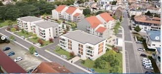 Aerial view of a residential area featuring multiple modern apartment buildings with flat roofs and red-tiled sections. The buildings are surrounded by landscaped greenery, including trees and lawns. Several parked cars line the streets and parking lots. The neighborhood consists of similar architectural styles and is interspersed with roads and pathways.