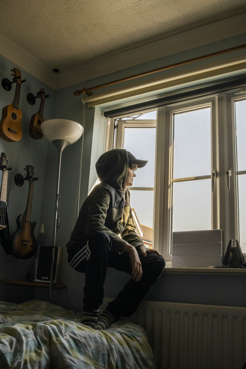 man in gray jacket sitting on chair beside window