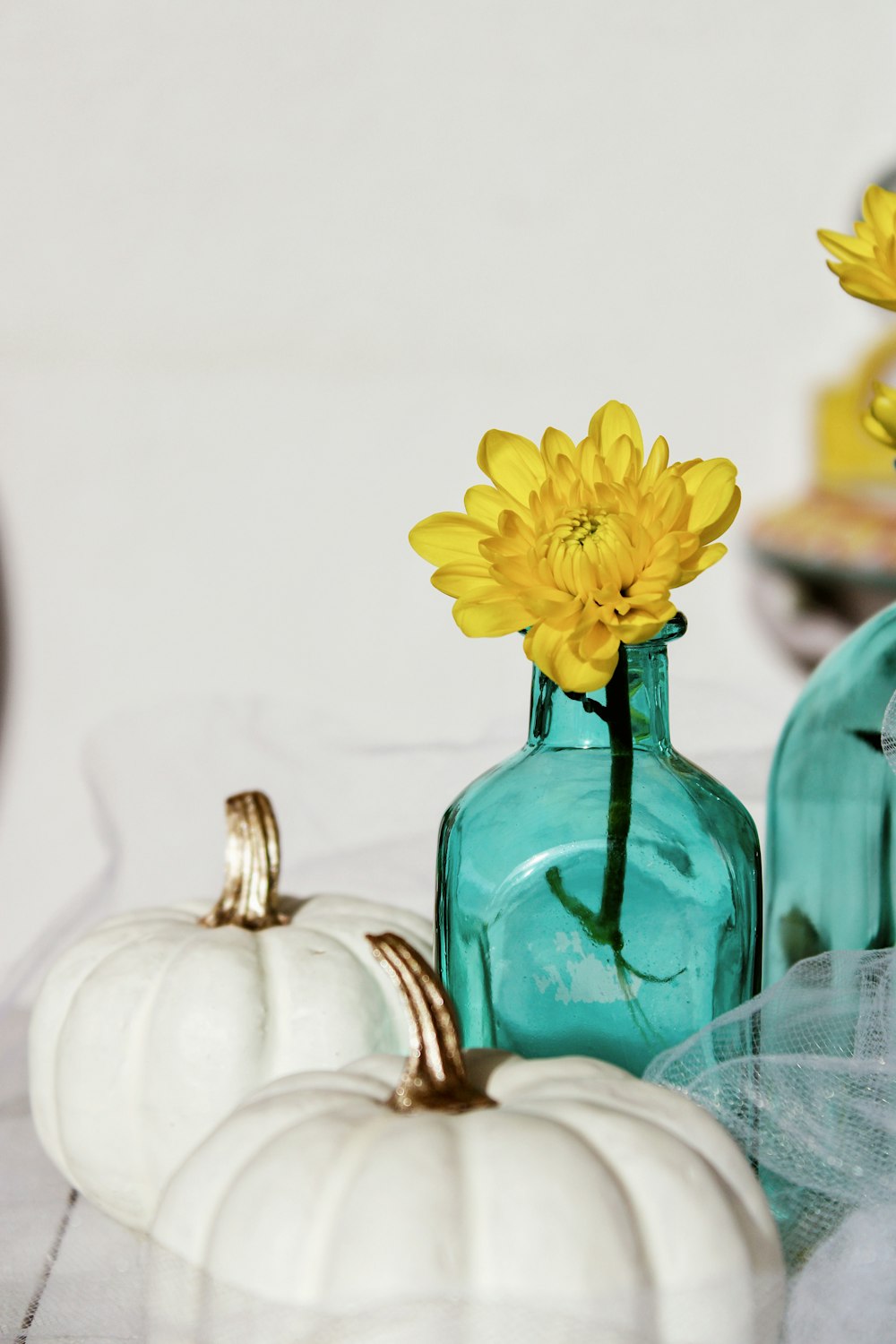 yellow flowers in green glass vase