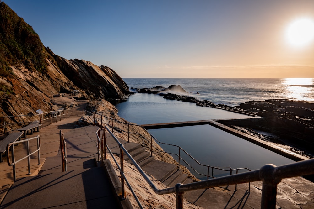 brown wooden railings on brown sand near body of water during daytime