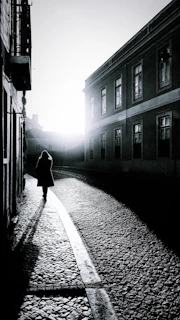 woman in black coat walking on street during daytime