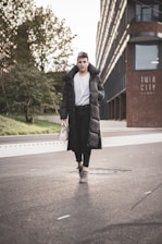 Model walking confidently through a bustling city street wearing eira pret apparel.