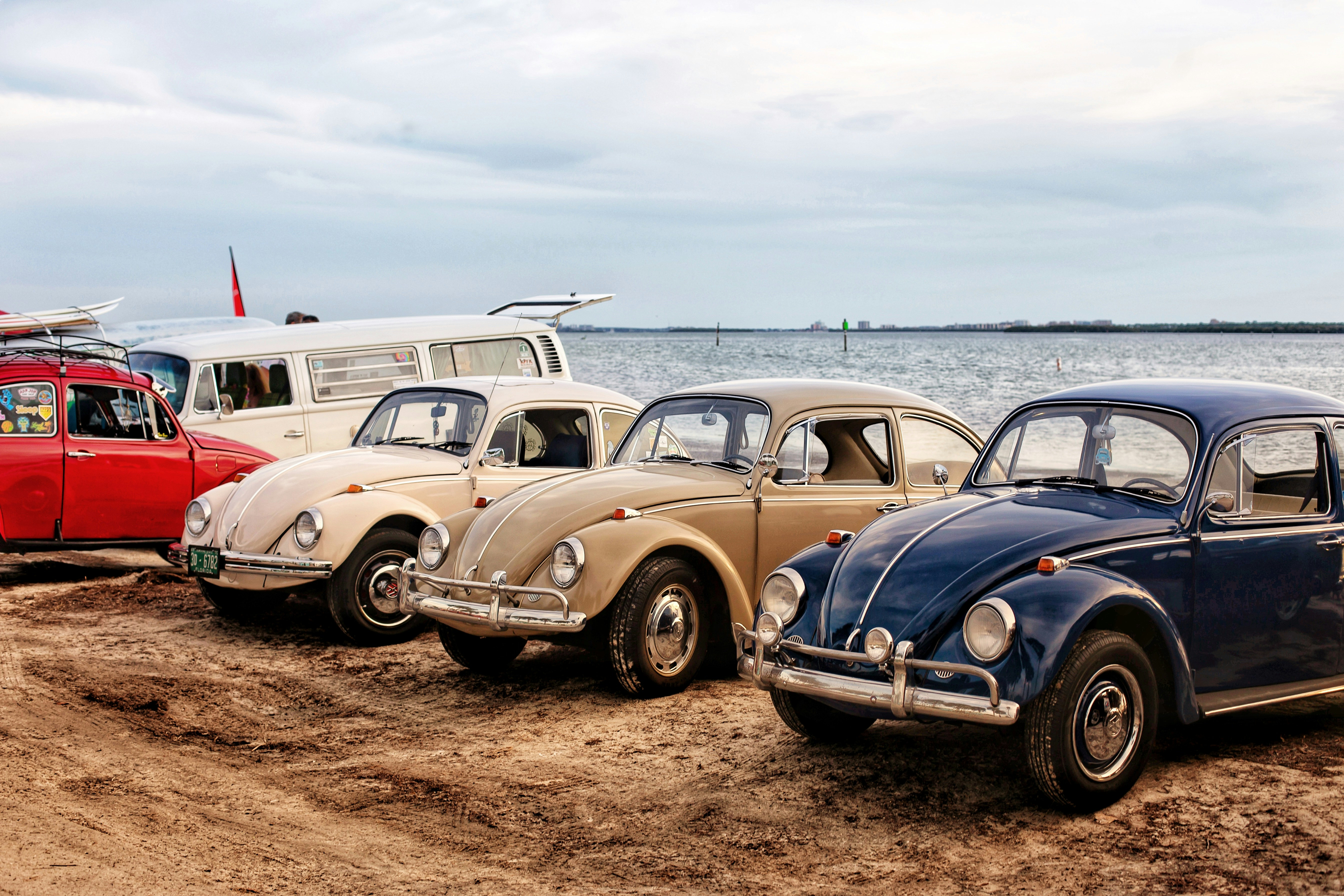 blue and white vintage car on brown sand during daytime