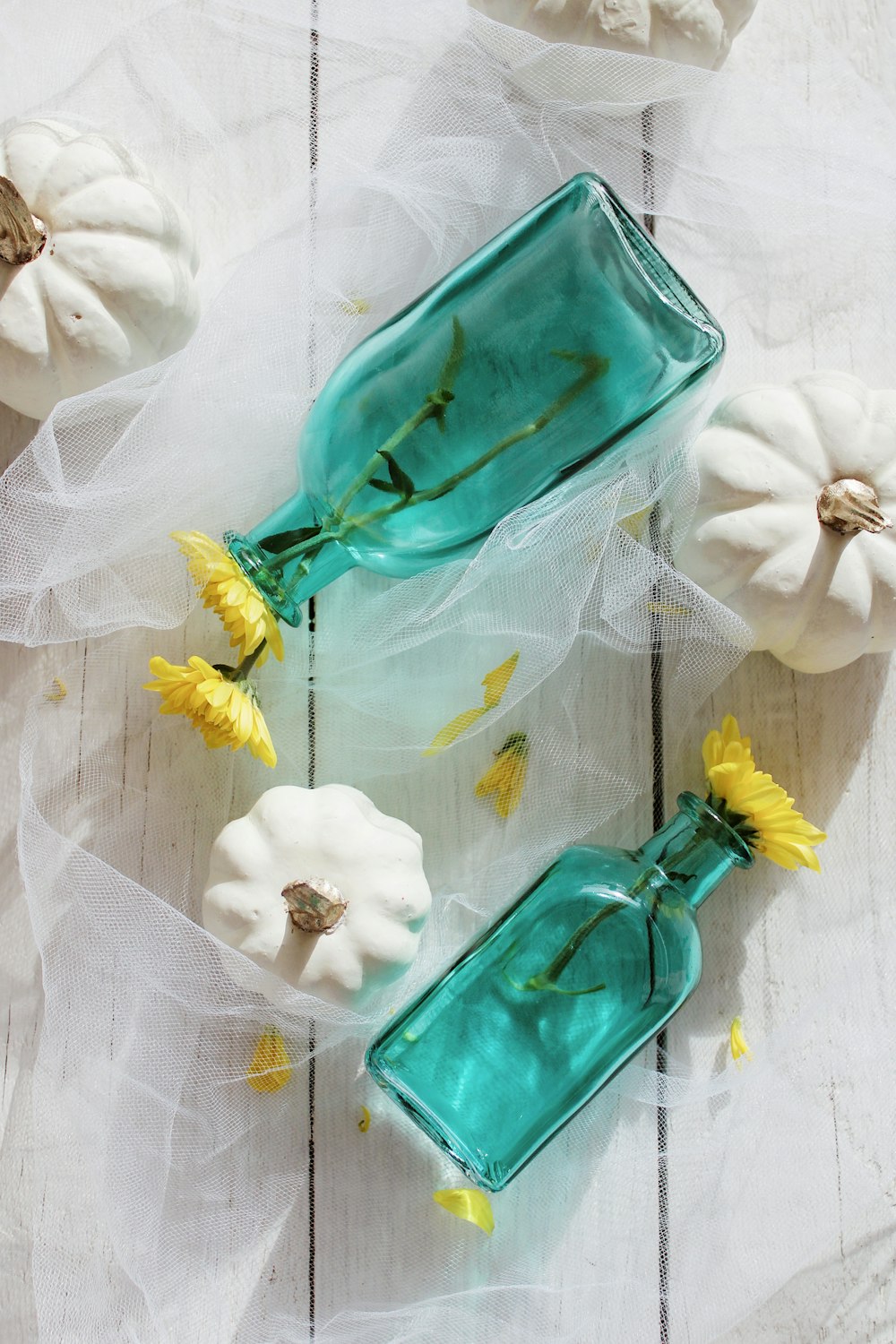 green glass bottle with white flower