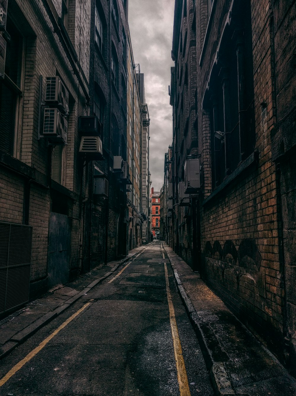 昼間のコンクリートの建物の間の空いている道路