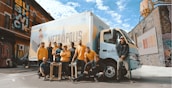 group of people standing beside white van during daytime