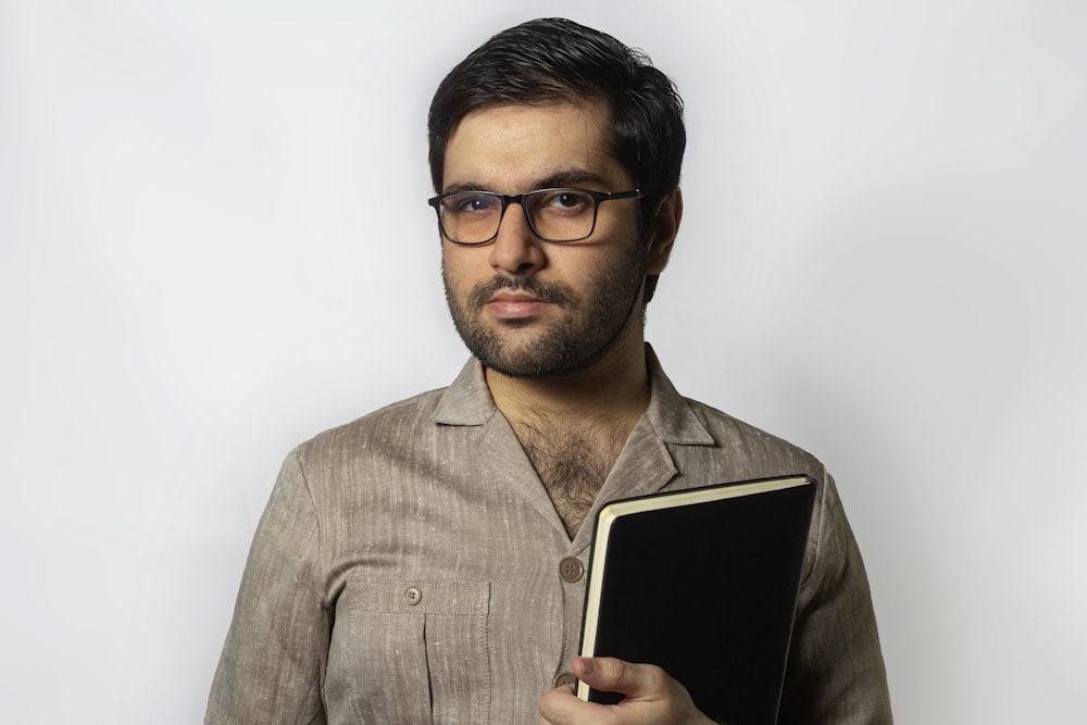 Hombre con chaqueta de traje gris sosteniendo un iPad blanco