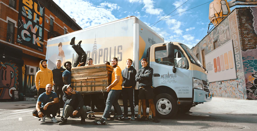 Movers working beside a white van outside an apartment building