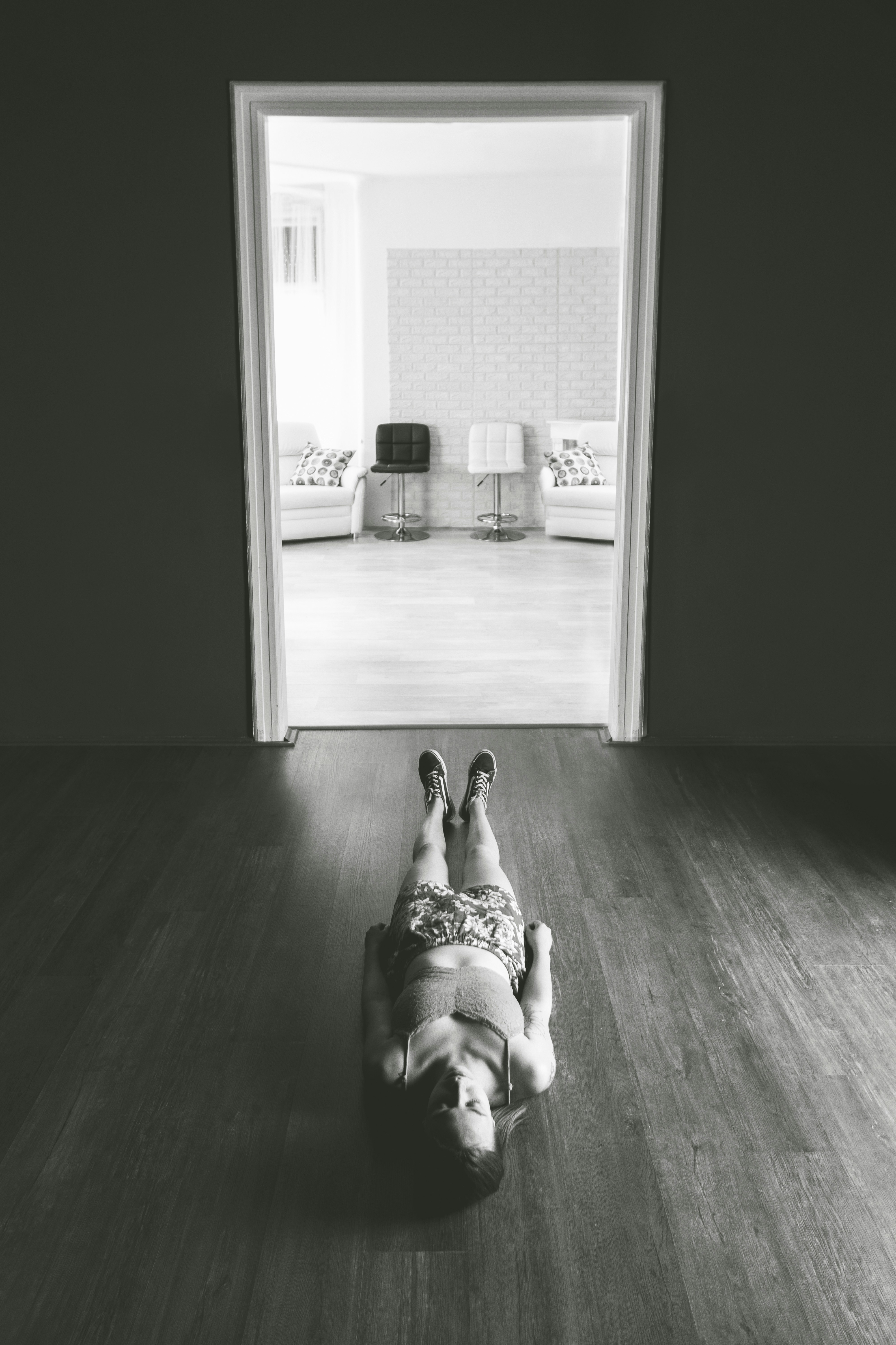 person in white pants and black shoes sitting on floor