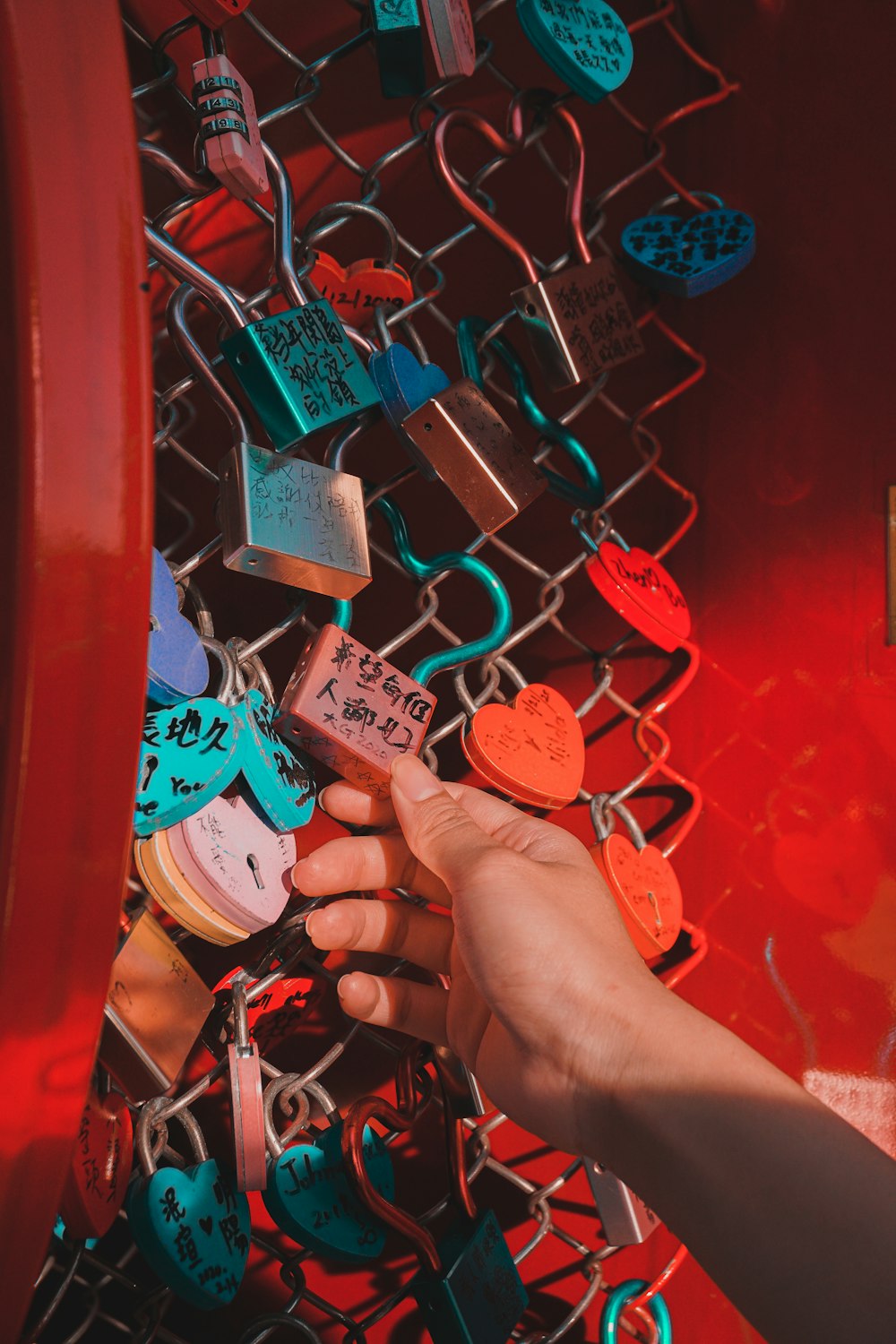 person holding red padlock with padlock
