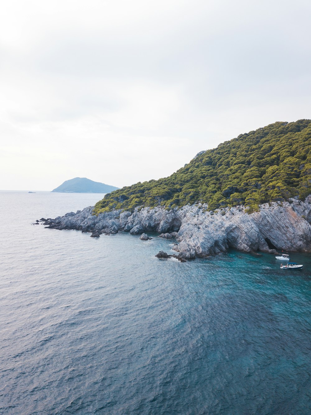 green and gray mountain beside body of water during daytime