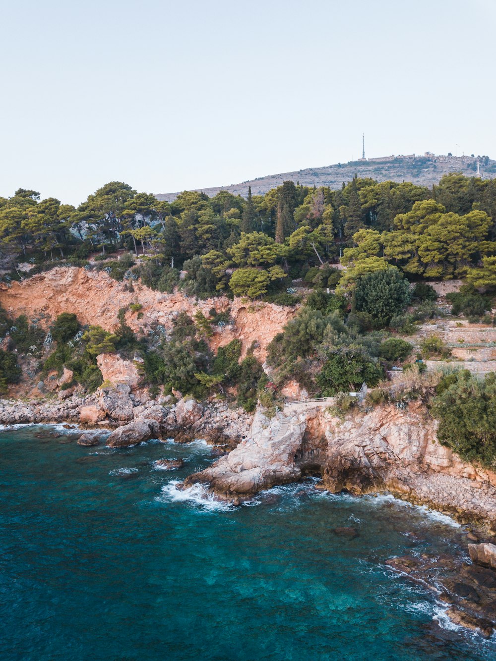 an aerial view of a rocky coastline with clear blue water