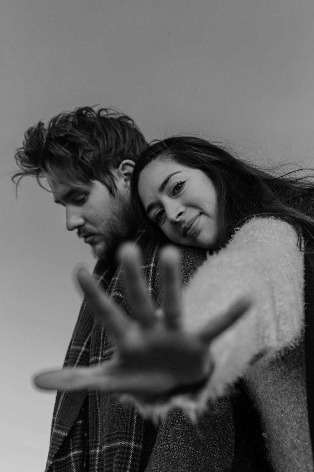 grayscale photo of woman hugging man