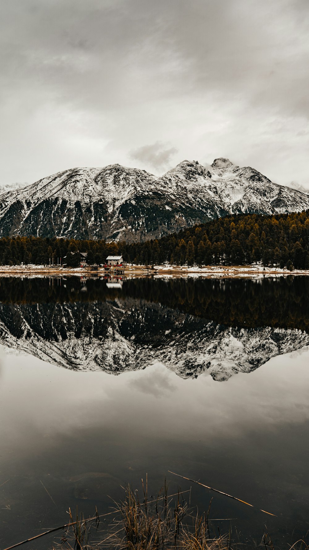 snow covered mountain near body of water during daytime