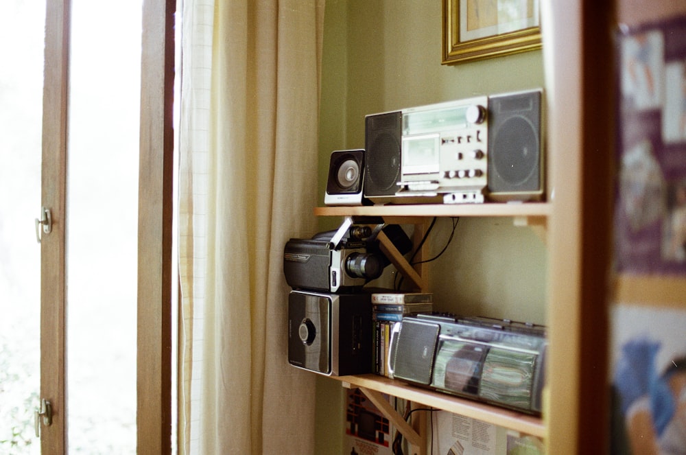 black and silver stereo component on brown wooden shelf