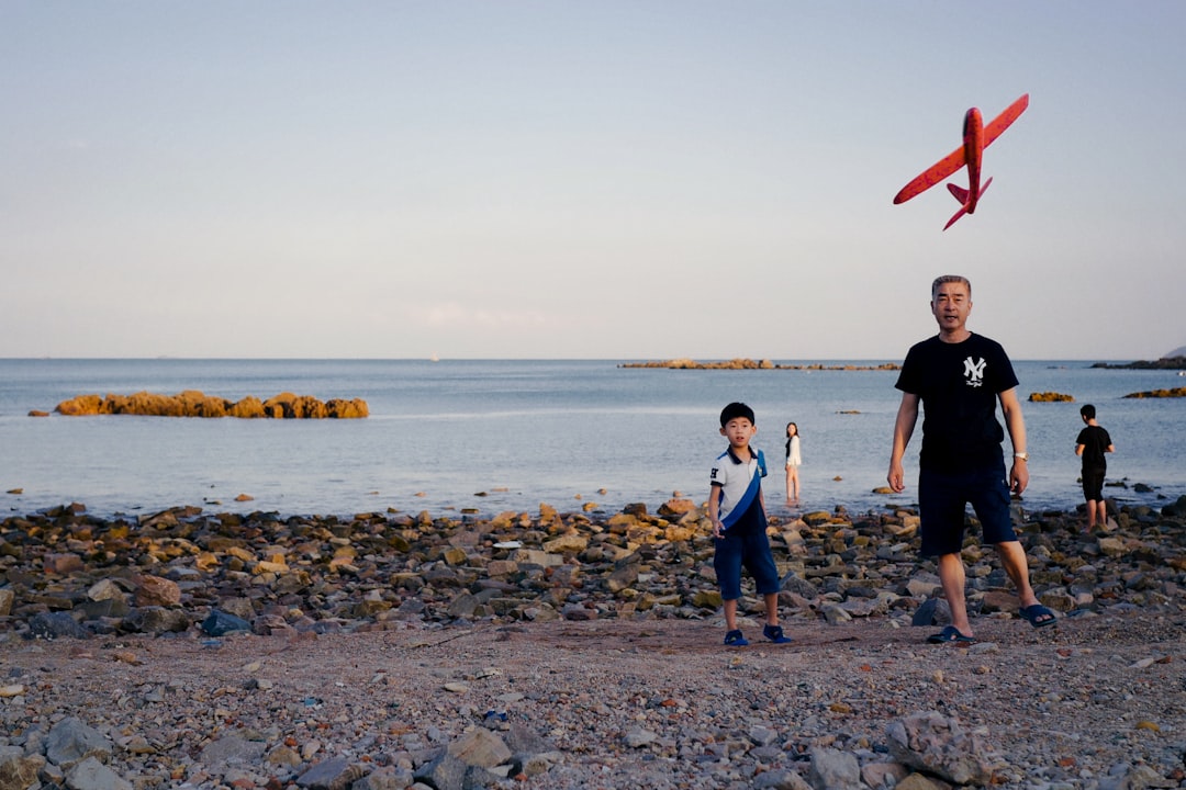 3 women standing on rocky shore during daytime