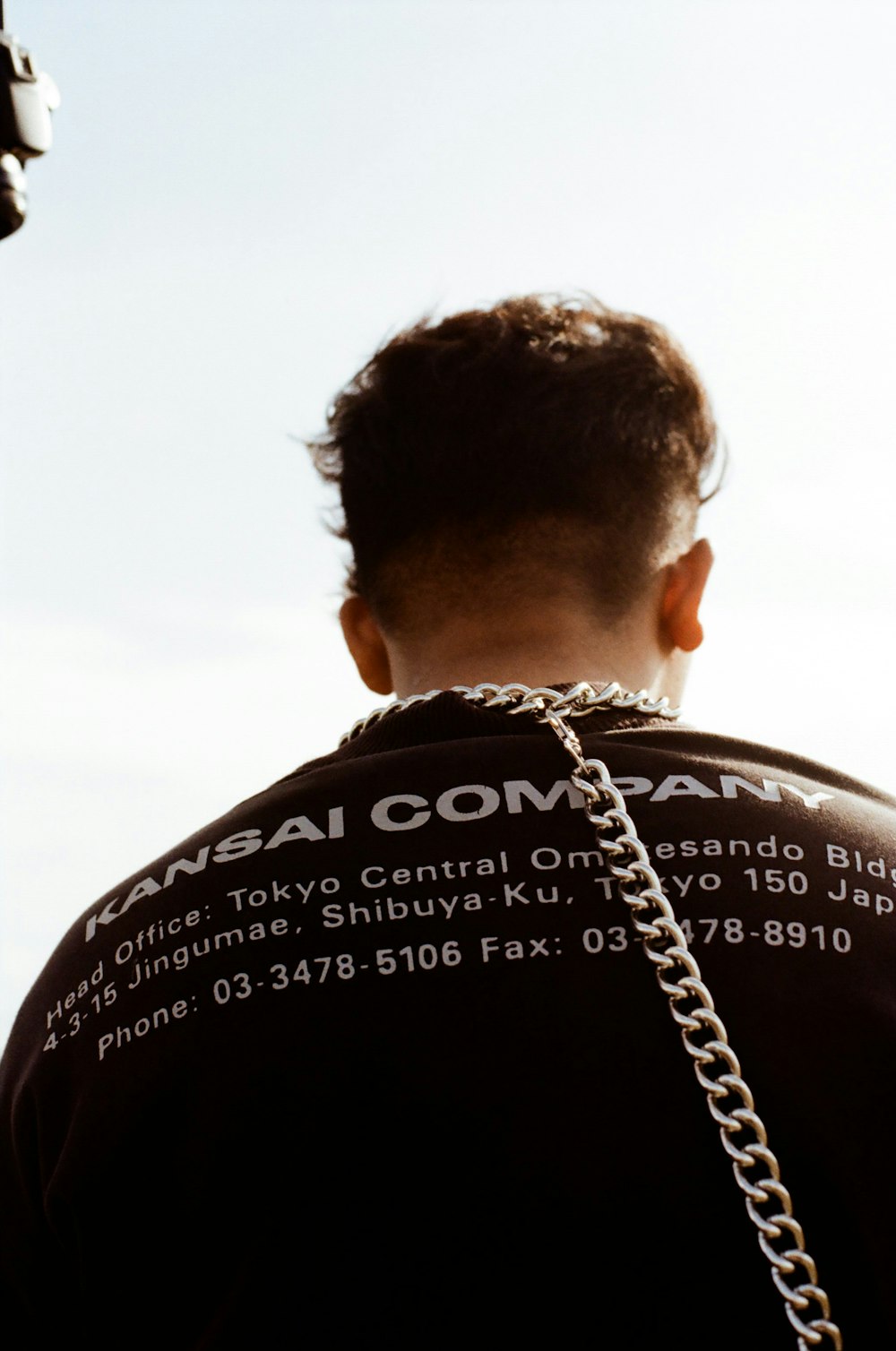 man in black shirt with silver chain necklace