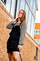 A young person in a monochrome fenr upper wear standing against an urban wall, showcasing the fabric texture.