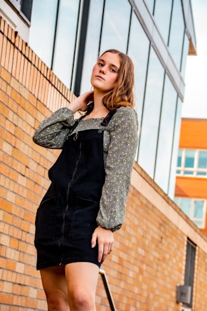 A young person in a monochrome fenr upper wear standing against an urban wall, showcasing the fabric texture.