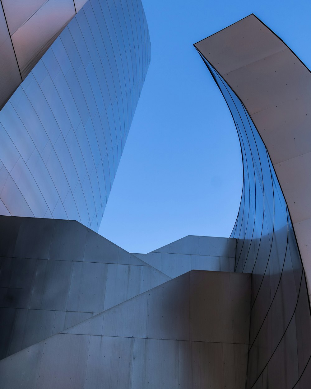 Graues Betongebäude unter blauem Himmel tagsüber