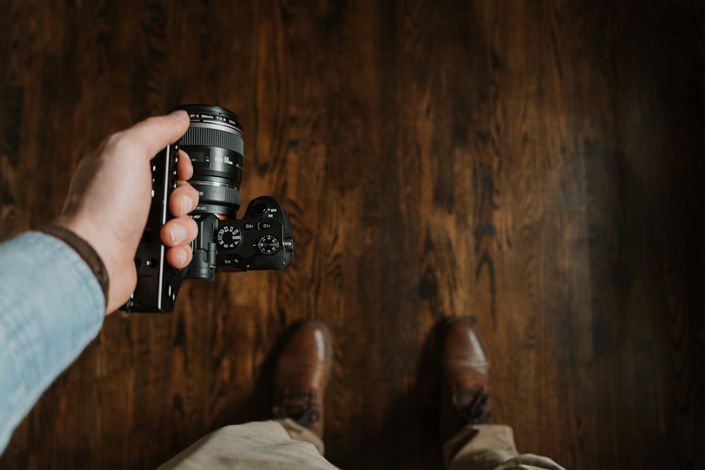 person holding black dslr camera