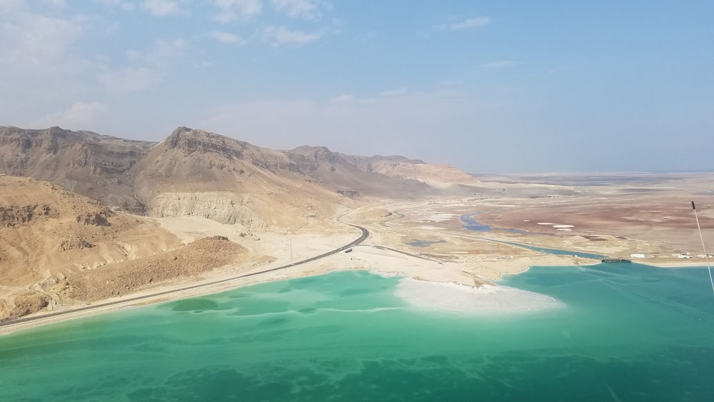 brown mountain near body of water during daytime