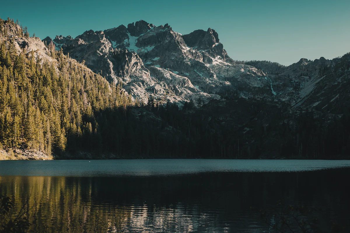 The jagged Sierra Buttes above Sardine Lake and its fir forest, the water still