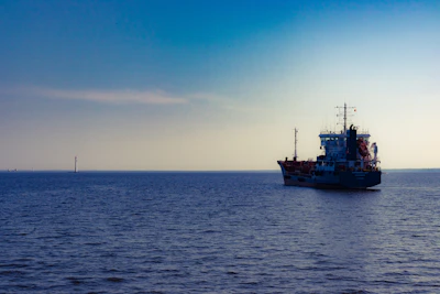 A sleek modern ship navigating calm blue waters under a clear sky, symbolizing reliability and professionalism.