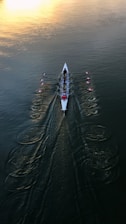 person in white shirt and black pants riding white surfboard on body of water during daytime