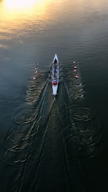 person in white shirt and black pants riding white surfboard on body of water during daytime