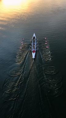 person in white shirt and black pants riding white surfboard on body of water during daytime