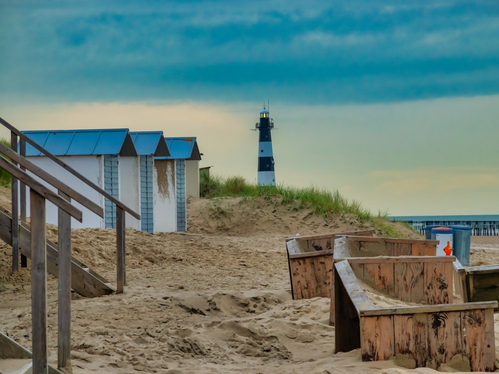 white and blue wooden house on brown sand under blue sky during daytime