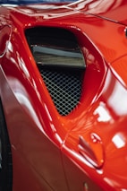 red car with white metal grille