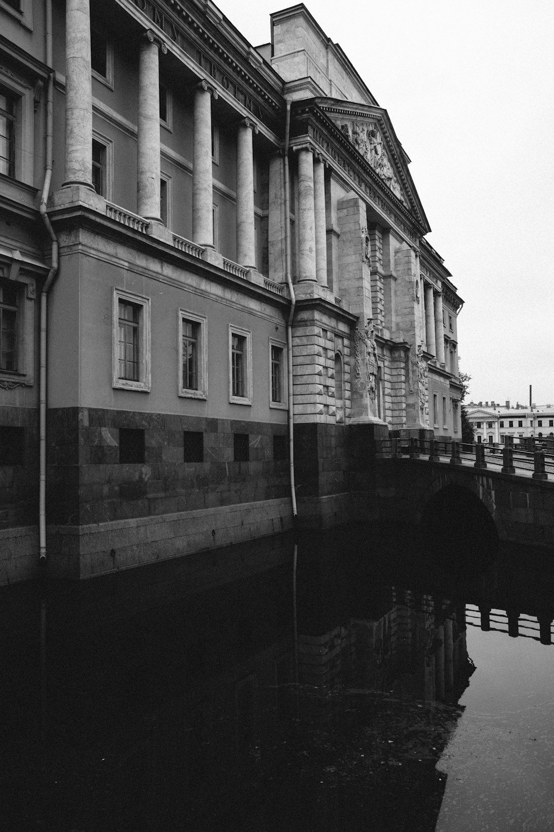 grayscale photo of concrete building near river