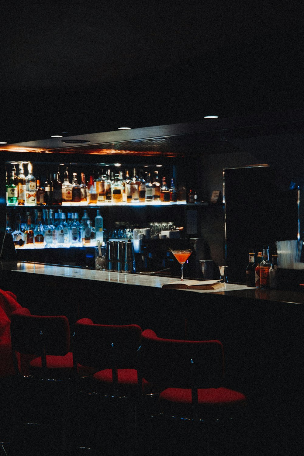 brown wooden bar stools with bottles