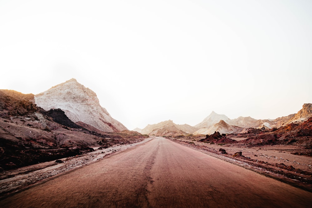 brown sand near white and brown mountains during daytime