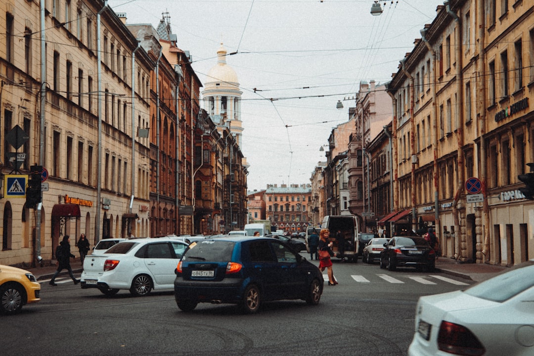 cars parked on side of the road in between buildings during daytime